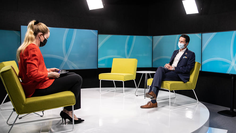 Tilaisuuden juontaja Annika Damström haastattelee kestävän kehityksen toimikunnan pääsihteeri Sami Pirkkalaa tv-studiossa.