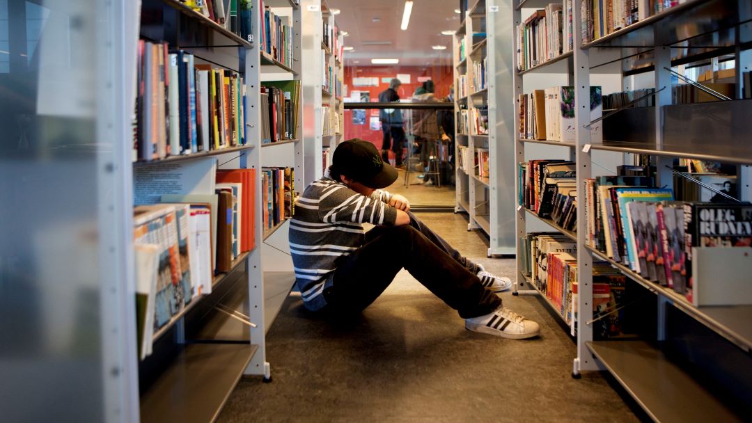 En pojke på bibliotekets golv