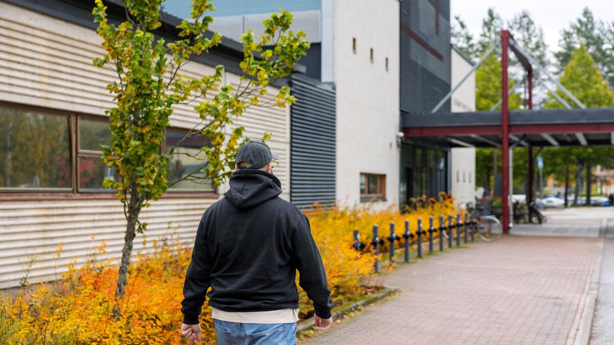 Kuvassa henkilö kävelee terveysasemaa kohti.