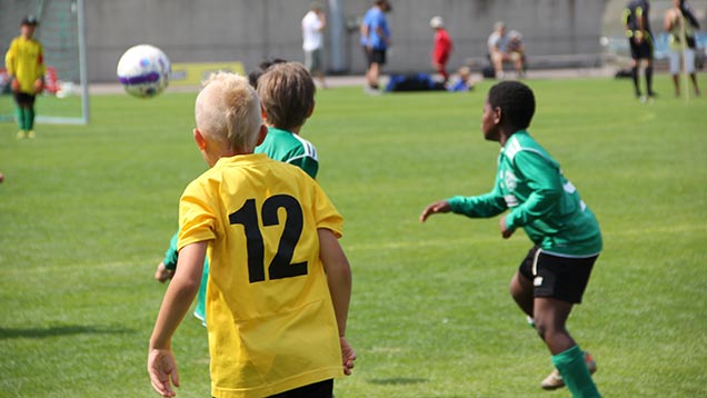 Poikia pelaamassa jalkapalloa.