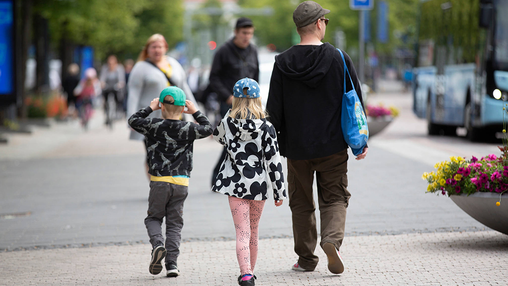 En far med sina barn på gatan