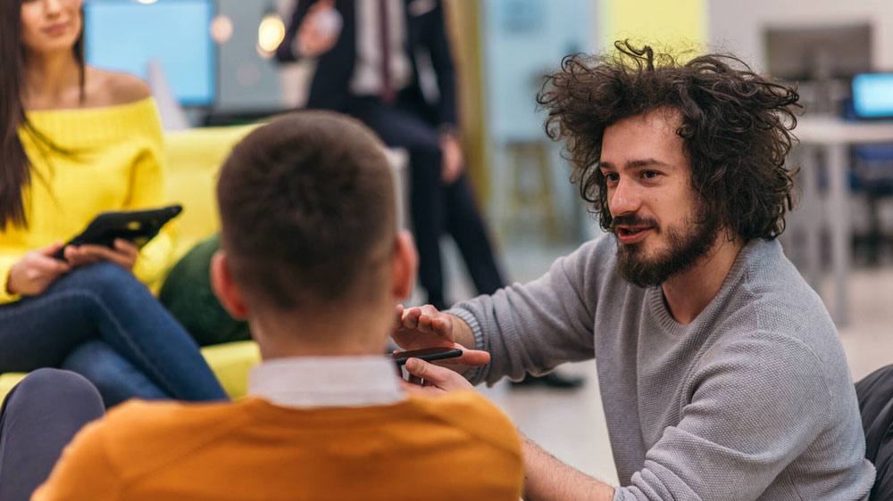 A few colleagues have a chat in office lobby.